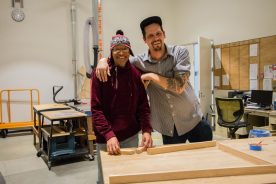 Two people beside a workshop bench