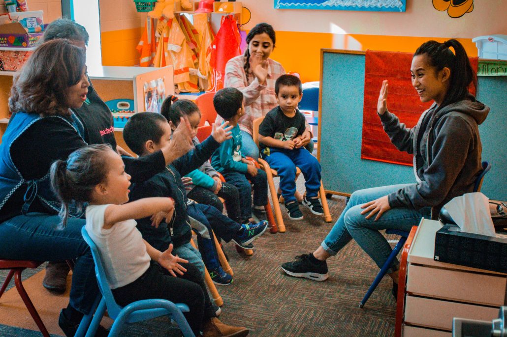 Seated children and adults in an activity room